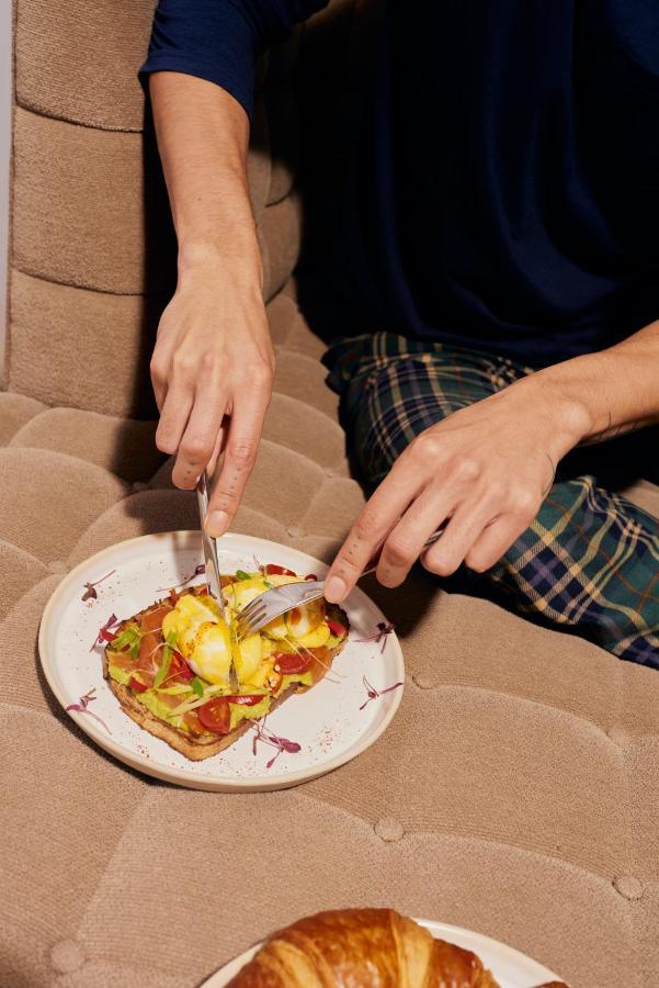 샌더슨 호텔 런던 외부 사진 A person using a knife and fork to cut food