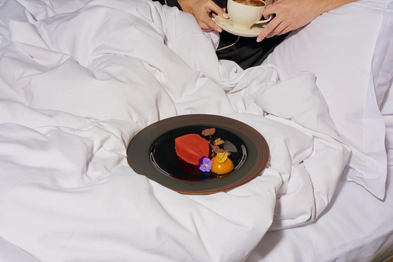 샌더슨 호텔 런던 외부 사진 A woman eating a heart-shaped dessert