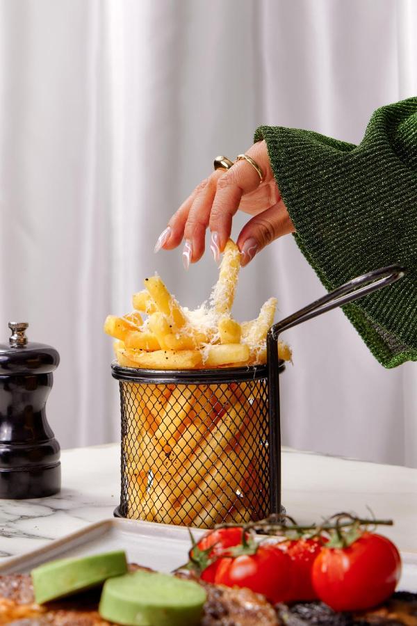 샌더슨 호텔 런던 외부 사진 Parmesan cheese being sprinkled on chips